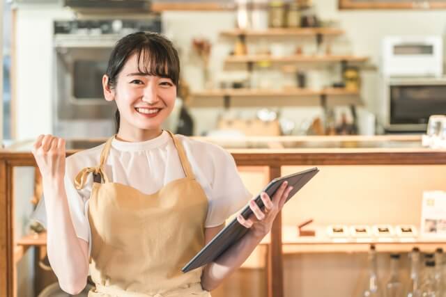 カフェでタブレットを持つ女性スタッフ