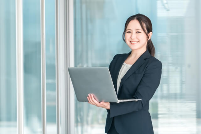 明るいオフィスで微笑むビジネス女性