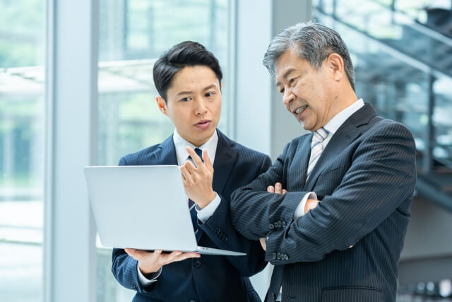 オフィスでノートパソコンを見る二人